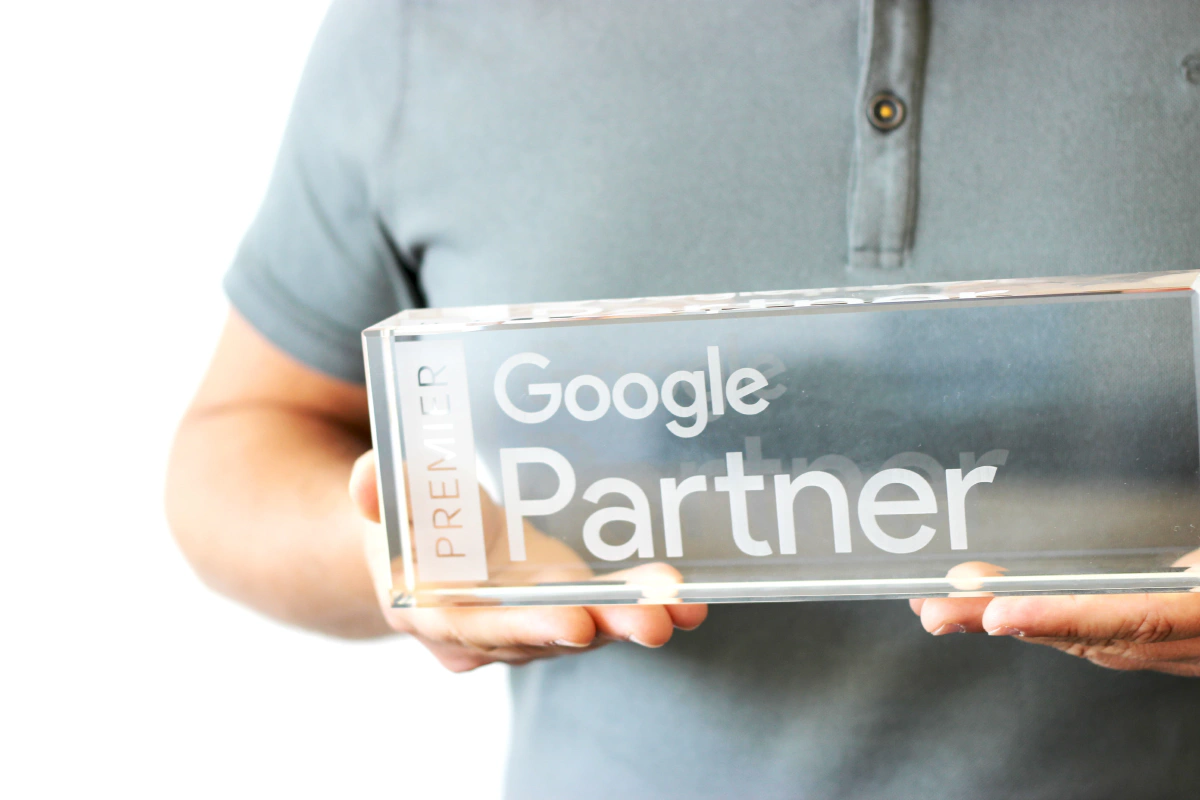Kollege bei tms hält unsere Auszeichnung als geprüfter Google Partner in der Hand.